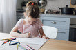 © LUMINA IMAGES - Cute little Caucasian girl drawing with crayons on kitchen table.