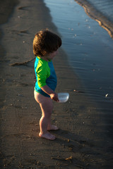 Toddler baby playing in shallow sea water