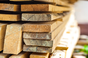 Canvas Print - Stack of building lumber at construction site with narrow depth of field. Timber wooden bars.