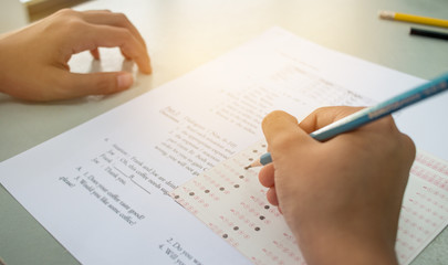 Wall Mural - asian student testing english exam or exercise on exams answer sheets with pencil in class room at s