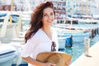 Beautiful young woman on vacation in a port in an Italian town. Summer concept