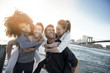 © goodluz - Group of friends enjoying sunset on Brooklyn heights promenade, NYC