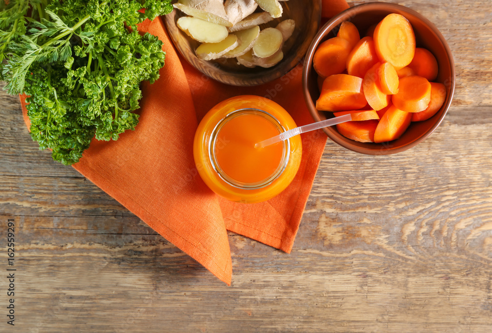 Jar of carrot juice on wooden table