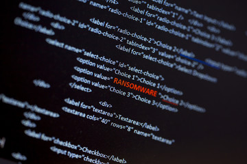 Wall Mural - ransomware text in red in the middle of the computer screen surrounded by computer code language. im