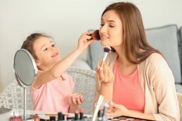 Sticker - Young woman and her little daughter applying makeup at home