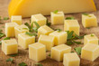 Close up of cubes of yellow cheese with herbs