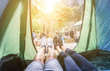 Pov view of happy couple inside tent at camping wood festival - Young people having fun on summer vacation into the wood - Travel,love,nature concept 