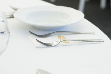 table setting with forks, plates and glass, restaurant, ceremony or wedding table