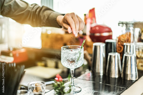 Fotografía Bartender preparing cocktail with gin , rosemary and pink pepper inside bar - So