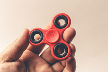 Male Hand Holding Popular Red Fidget Spinner Toy