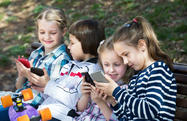 Wall Mural - Portrait of little kids playing with phones