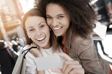 Wall Mural - Girls on a shopping day showing card to camera