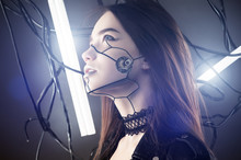 Beautiful Robot Girl In Cyberpunk Style Looking Up On Background Of Wires And Glowing Lamps