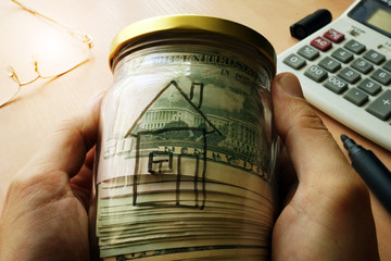 Wall Mural - Jar with dollars and house on a side. Real estate rent and buy concept.