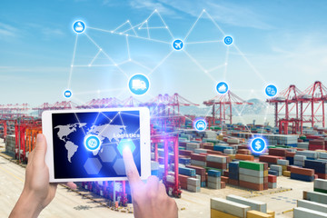 Wall Mural - Hand holding tablet is pressing button Logistics connection technology interface global partner connection for logistic import export background. Business logistics concept , internet of things