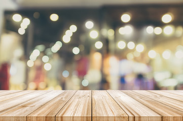 Wall Mural - Empty wooden table top with blurred modern shopping mall background. Vintage color tone.