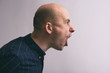 Side view of a handsome bald man screaming