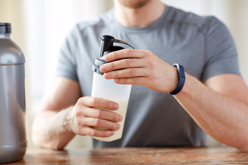 Wall Mural - close up of man with protein shake bottle and jar