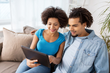 Poster - smiling happy couple with tablet pc at home