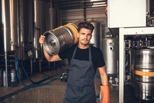 Male Brewer Carrying Metal Container At Brewery Factory
