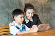 © kanchitdon - Asian, mother and son sitting, playing tablet together.