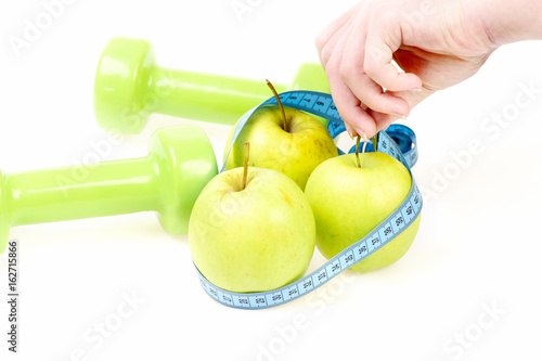 Photographie Trio of apples wrapped with cyan flexible ruler in hands