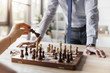 © LIGHTFIELD STUDIOS - partial view of businessman playing chess with colleague in office