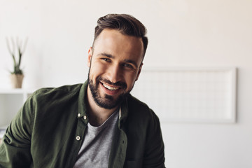 Close-up portrait of handsome bearded man smiling at camera