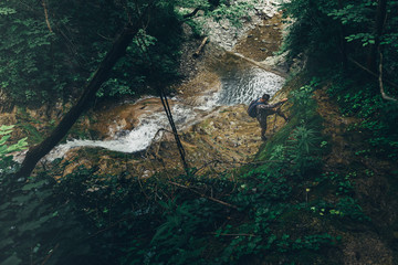 Wall Mural - Male Climber Climbs The Hill On Waterfall Background Hiking Mountain Adventure Concept