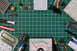 DIY electrical maker tools components on green cutting mat board. DIY electrical maker tools with copy space for text on green background. DIY electrical handmade tools electronic maker components.
