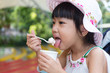 Leinwandbild Motiv Asian Chinese little girl eating ice cream