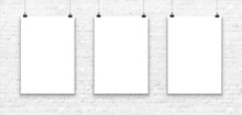 Three Blank Paper Poster Mockup On A White Brick Wall.
