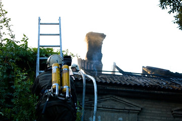 Firemen In a special form on the roof of a burning house