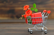 Valentines Day Gift Shopping Background Concept With Copy Space. Shopping Cart With Gift Box And Red Roses 