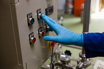 Cropped hand of worker pressing button of machinery