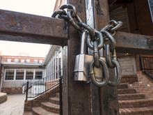 Padlock And Chain On Gate In Front Of An Establishment's Courtyard