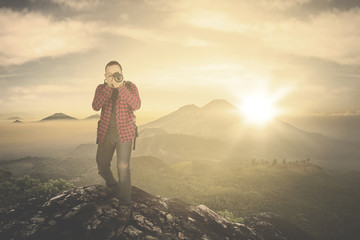 Wall Mural - Man taking photo on mountain peak