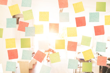 Empty sticky note on window in the office with vintage tone and sun light.