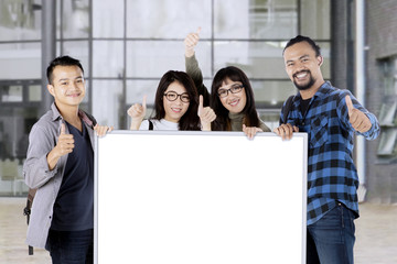 Wall Mural - University students showing ok sign and board