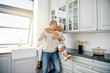 © Flamingo Images - Laughing senior couple sharing a romantic moment in their kitchen