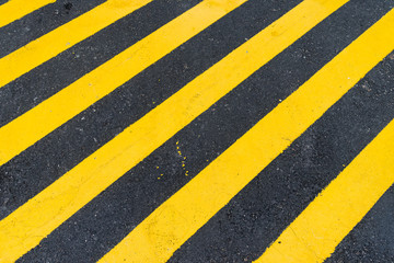 Asphalt Background with diagonal black and yellow warning stripes