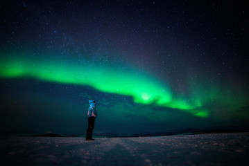 girl watching the northern lights. abisko sweden