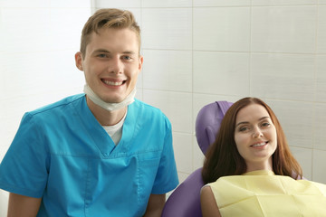 Wall Mural - Happy young woman and male dentist after treatment in clinic