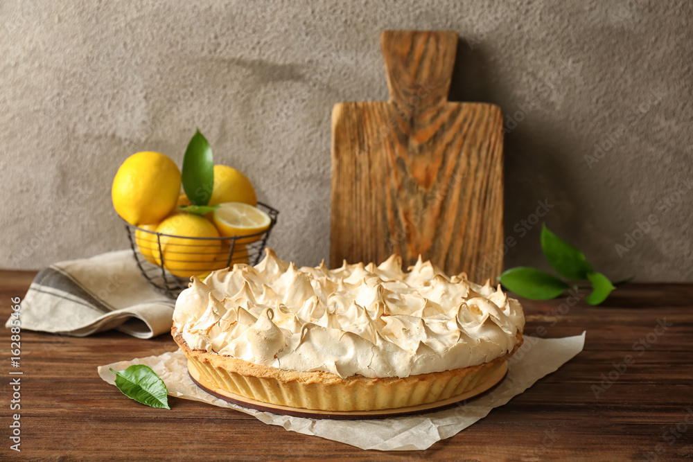 Composition with tasty lemon meringue pie on wooden table