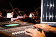 © princeoflove - sound engineer hands working on digital sound mixer for symphony orchestra live concert recording