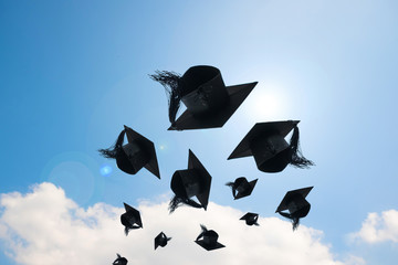 Graduation day, Images of graduation Caps or hat throwing in the air with sunshine day on blue sky background, Happiness feeling, Commencement day, Congratulation, Ceremony