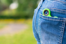 Green Spinner Toy For Nerve Lies In A Pocket On A Background Of Green Grass