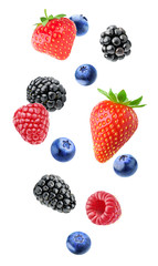 Isolated mixed berries in the air. Falling blackberry, raspberry, blueberry and strawberry fruits isolated on white background with clipping path