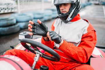 Wall Mural - Go-kart driver in helmet on karting speed track