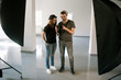 © Photodrive - Photographer speaks with model on photoshoot. Man with camera show pictures to casual woman during the studio session. Production of commercials backstage